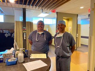 两个穿着手术服的医务人员站在医院大厅里